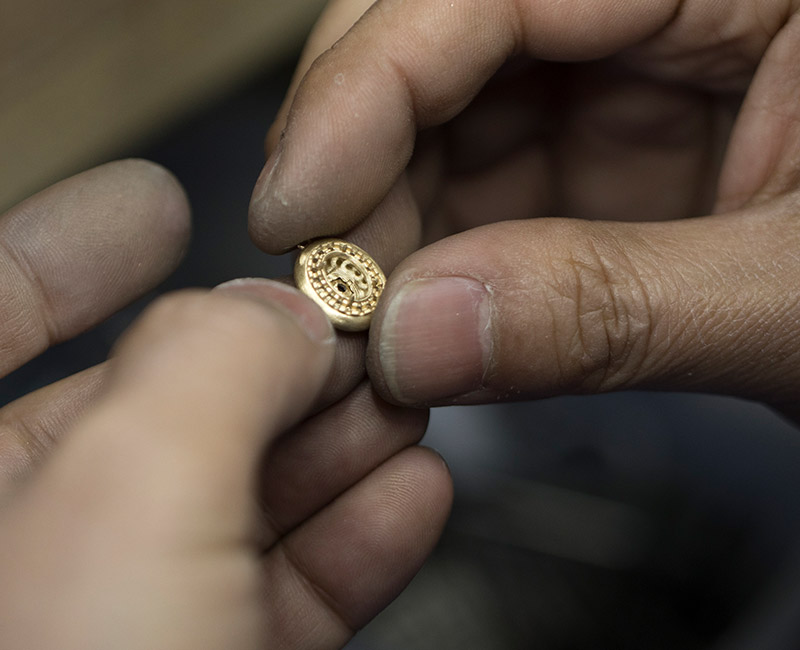 Artisan expert démontrant un savoir-faire unique sur un établi de joaillerie traditionnelle.