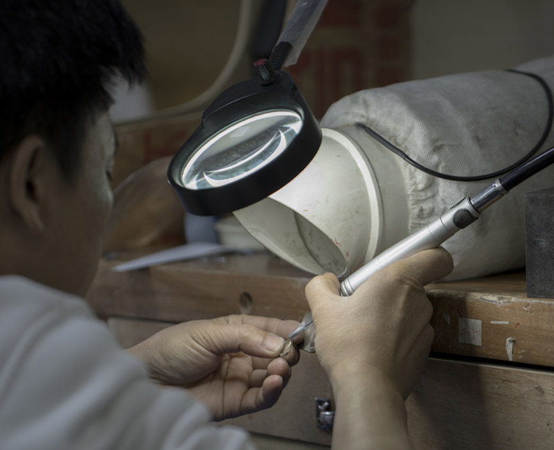 Artisan expert démontrant un savoir-faire unique sur un établi de joaillerie traditionnelle.